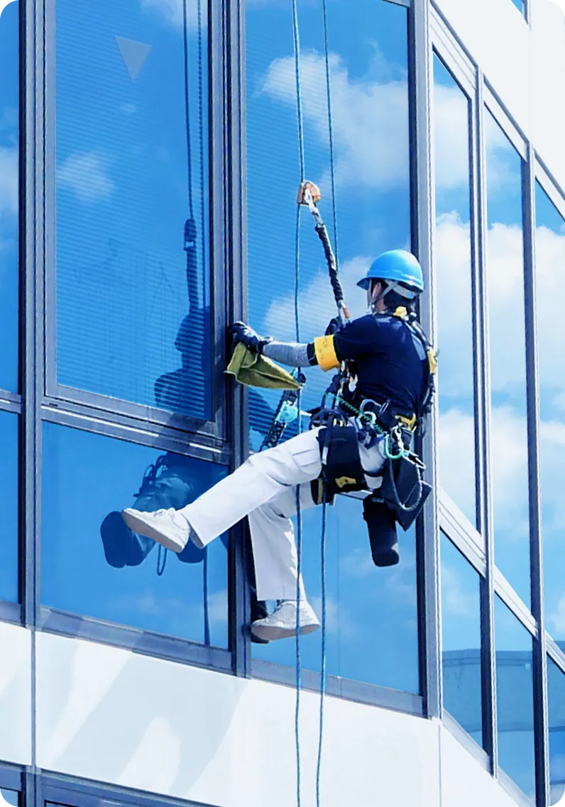 窓ガラスを清掃する男性スタッフの写真